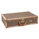 A VINTAGE LOUIS VUITTON BROWN LEATHER SUITCASE with studded brass corner mounts, fasteners and
