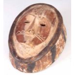 AN ANTIQUE AFRICAN CARVED WOOD CIRCUMCISION MASK with white and black painted decoration 27.5cm high