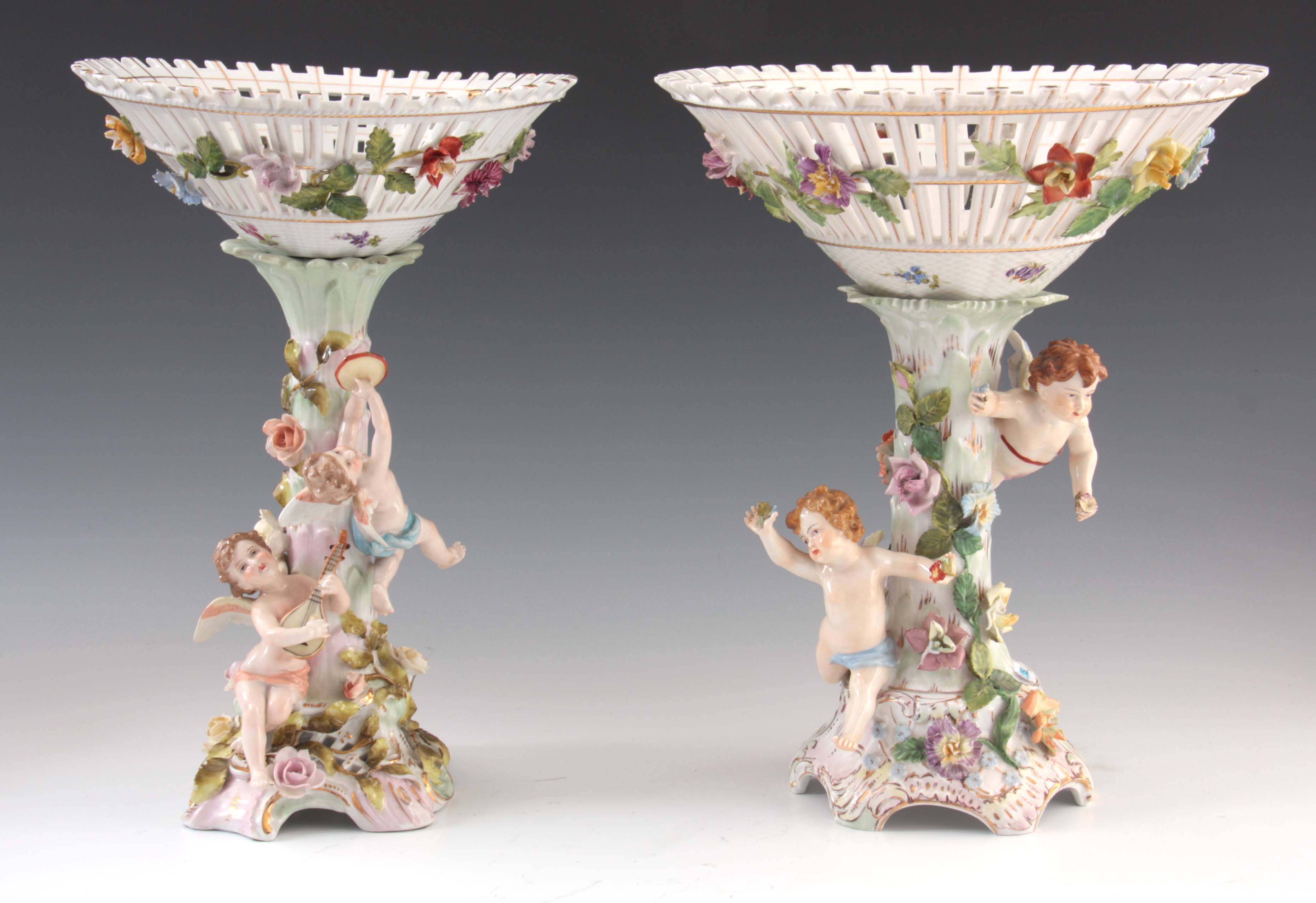 TWO 19TH CENTURY DRESDEN PORCELAIN COMPOTE CENTREPIECES with figural cherub bases and pierced basket
