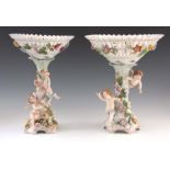 TWO 19TH CENTURY DRESDEN PORCELAIN COMPOTE CENTREPIECES with figural cherub bases and pierced basket