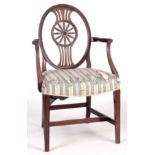 A 19TH CENTURY SHERATON STYLE OPEN ARMCHAIR with oval back having a carved floral centre, swept open