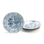 FOUR 18TH CENTURY DELFT BLUE AND WHITE PLATES decorated with floral designs 23cm diameter.