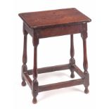 A 18TH CENTURY JOINED OAK STOOL with nailed top on a slender splayed baluster turned base with