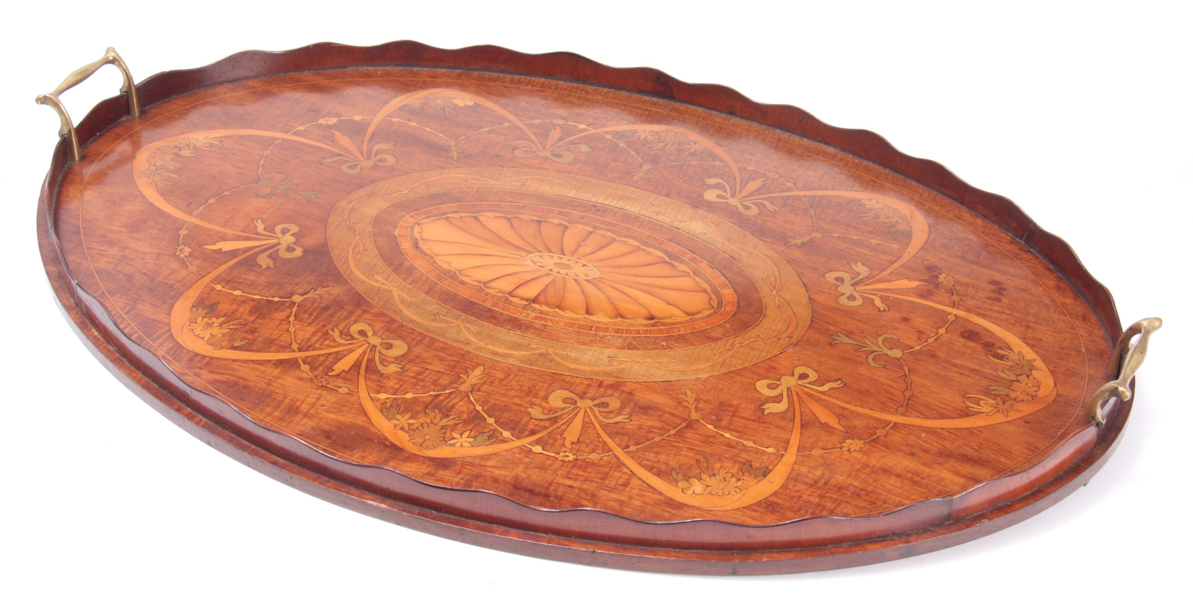 A 19TH CENTURY INLAID MAHOGANY OVAL TRAY with brass side handles and wavey edge gallery 71cm wide