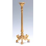 A 19TH CENTURY FRENCH EMPIRE STYLE GILT BRASS CANDLESTICK with tapering reeded stem and leaf cast