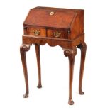 A GEORGE I STYLE WALNUT BUREAU ON STAND with angled fall revealing an interior of pigeon holes and