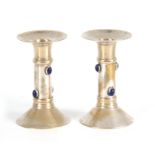 A PAIR OF 20TH CENTURY ARTS AND CRAFTS SILVER PLATED CANDLESTICKS each mounted with 4 blue glass