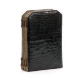 AN EARLY 20TH CENTURY BLACK ALLIGATOR SKIN FOLDING TRAVELLING PHOTO FRAME with black and white