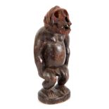 A LATE 19TH CENTURY AFRICAN CARVED FIGURE with monkey skull head on stained wooden body - 39cm high