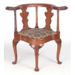 A 19TH CENTURY GEORGE I STYLE WALNUT CORNER CHAIR with carved eagles head top rail above solid