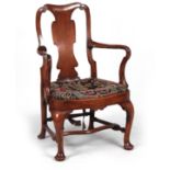 A GEORGE I WALNUT OPEN ARMCHAIR with scrolled top rail above a shaped back splat joined by shepherds