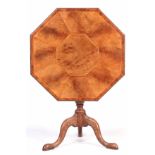 A GEORGE III OCTAGONAL SHAPED TILT TOP TABLE with figured and burr Elm segmented top; standing on an