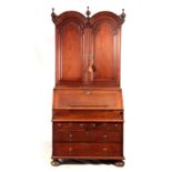 A WILLIAM AND MARY WALNUT BUREAU BOOKCASE the double-domed top with fielded panelled doors revealing