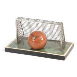 A VINTAGE NOVELTY DESK CLOCK MODELED AS A FOOTBALL with chrome goals and simulated grass plinth 22cm