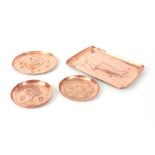A COLLECTION OF FOUR ARTS AND CRAFTS COPPER TRAYS a rectangular tray with embossed fish 22cm wide, a