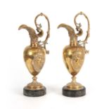 A PAIR OF LATE 19TH CENTURY BRONZE EWERS having shaped spouts and leaf cast handles, with applied