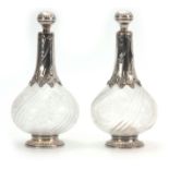 A PAIR OF EARLY 19TH CENTURY CONTINENTAL SILVER MOUNTED BULBOUS DECANTERS the swirl fluted bodies