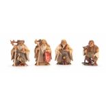 A SET OF FOUR EARLY 20th CENTURY STAINED IVORY NETSUKE sculptured as for elderly men, all with