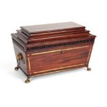 A REGENCY BRASS INLAID MAHOGANY SARCOPHAGUS SHAPED TEA CADDY with reeded frieze and lions paw