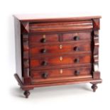 A 19TH CENTURY MAHOGANY MINIATURE CHEST OF DRAWERS with cushion-shaped secret top drawer above two