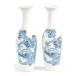 A SLENDER PAIR OF SMALL 18TH / 19TH CENTURY BLUE AND WHITE VASES decorated with dragons 20cm high.