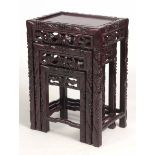 A NEST OF THREE 19TH CENTURY CHINESE HARDWOOD OCCASIONAL TABLES with fruiting leaf carved edges