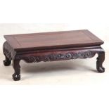 A 19TH CENTURY CHINESE HARDWOOD LOW OCCASIONAL TABLE with panelled top and shaped scroll carved base