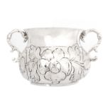 A CHARLES II SILVER YORK PORRINGER the body of baluster form chased with foliage and flowers flanked