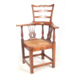 AN 18TH CENTURY ELM CORNER CHAIR with raised ladder back above a bowed armrest supported by