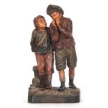 A 19TH CENTURY AUSTRIAN PAINTED TERRACOTTA FIGURE GROUP modeled as two standing boys labeled DU