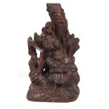 A 19TH CENTURY BLACK FORREST CARVED FIGURE GROUP with leaf work and tree trunk backing 51cm high