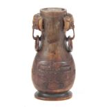 A CHINESE QING DYNASTY CARVED RHINOCEROS HORN SNUFF BOTTLE having masked hoop handles and raised