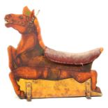 A VINTAGE PAINTED WOODEN FAIRGROUND HORSE with padded seat 104cm high, 107cm long