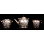 A LATE 19TH CENTURY AMERICAN SILVER AND MIXED METAL THREE-PIECE TEA SERVICE of planished form with