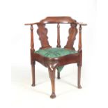 A GEORGE I WALNUT CORNER CHAIR with raised back on a shaped bowed armrest supported by turned
