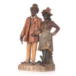 A 19TH CENTURY AUSTRIAN STYLE PAINTED TERRACOTTA FIGURE GROUP modelled as a well dressed standing