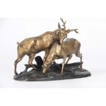 A LATE 19TH CENTURY FRENCH GILT METAL SCULPTURE modelled as a stag and hind on a naturalistic oval