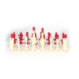 A 19th CENTURY INDIAN IVORY CHESS SET having natural and red-stained chess pieces, in a