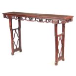 A 19TH CENTURY CHINESE HARDWOOD ALTAR TABLE with panelled top above a shaped carved frieze;