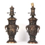 A PAIR OF 20th CENTURY BRONZE AND GILT BRONZE ORIENTAL LAMPS with relief cast birds and elephant