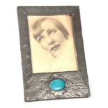 AN ARTS AND CRAFTS BEATEN PEWTER PHOTOGRAPH FRAME set with a blue Ruskin style large oval ceramic