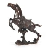 AN 18th CENTURY CHINESE BRONZE SCULPTURE OF A HORSE mounted on a naturalistic scrolled base 24cm