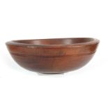 A LATE 19TH CENTURY TURNED FRUITWOOD KITCHEN BOWL of deep form with incised ringed border 36.5cm