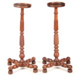 A PAIR OF EARLY 19TH CENTURY WALNUT TORCHERES with dished circular tops on ringed tapering reeded