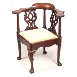 A GEORGE II MAHOGANY CORNER CHAIR with shaped armrest above turned supports and pierced back splats,