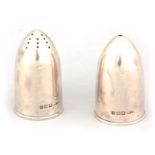 A PAIR OF GEORGE V NOVELTY BULLET SHAPED SILVER SALT AND PEPPER SHAKERS with knurl-edged removable