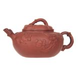 A CHINESE YIXING STYLE TERRACOTTA TEAPOT of oval shape with relief moulded flowers, branch work