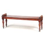 A 19TH CENTURY MAHOGANY WINDOW SEAT OF LARGE SIZE with roundel ends above ring-turned tapering leg