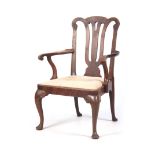 A 19TH CENTURY GEORGE I STYLE WALNUT OPEN ARMCHAIR with shaped scrolled top rail above a pierced