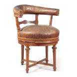 A 19TH CENTURY OAK REVOLVING DESK CHAIR with tanned leather upholstered backrest and seat on ring